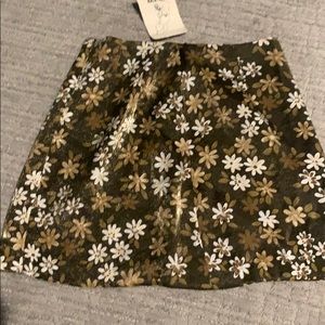 Slightly shiny brown skirt with floral pattern